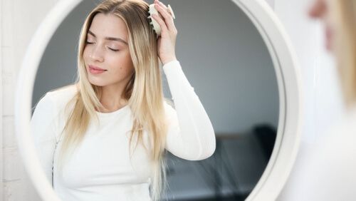 אישה דואגת לטיפול בקרקפת בעזרת עיסוי